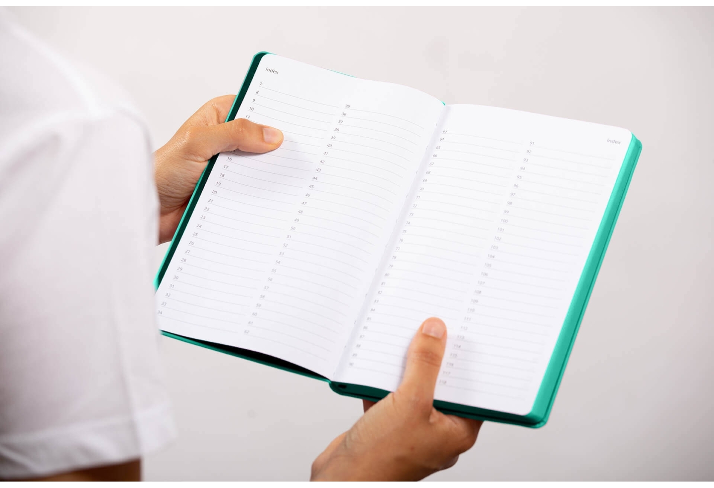 Carnet de note infirmière ouvert tenu en main par une professionnelle de santé – coloris vert aqua