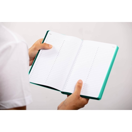 Carnet de note infirmière ouvert tenu en main par une professionnelle de santé – coloris vert aqua