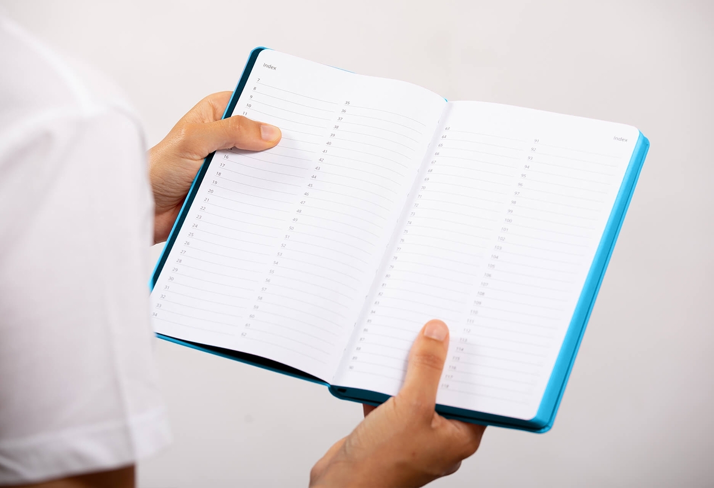 Carnet de note infirmière ouvert tenu en main par une professionnelle de santé – coloris bleu