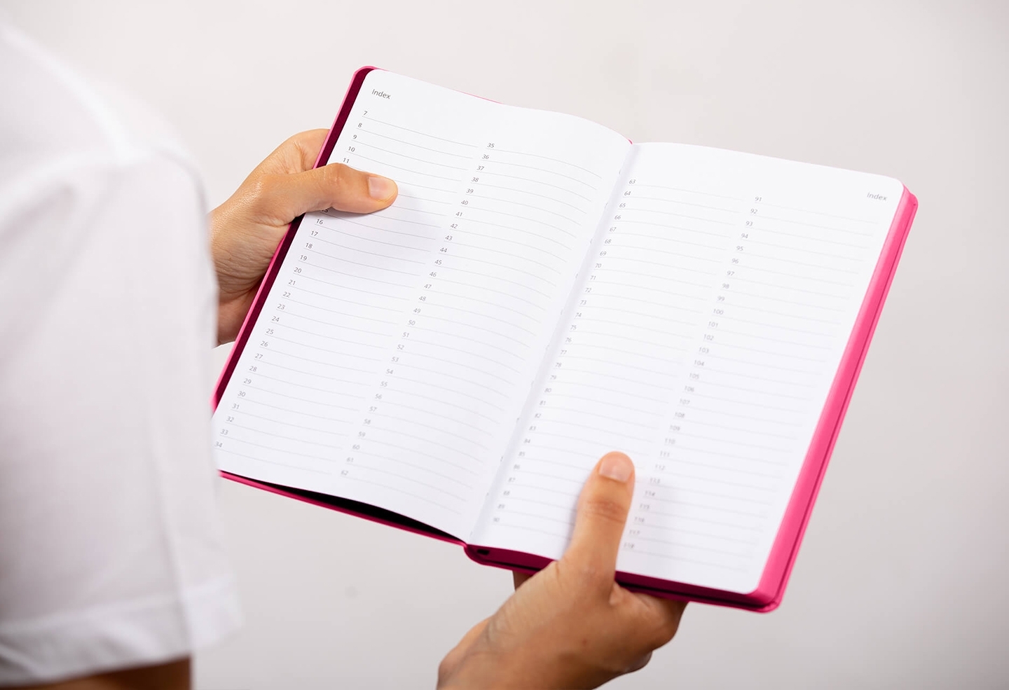 Carnet de note infirmière ouvert tenu en main par une professionnelle de santé – coloris rose