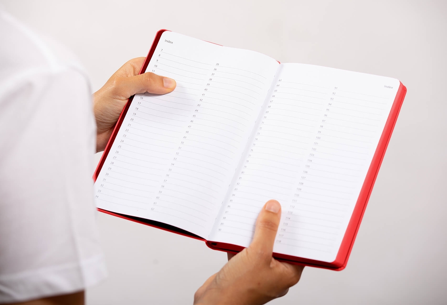 Carnet de note infirmière ouvert tenu en main par une professionnelle de santé – coloris rouge