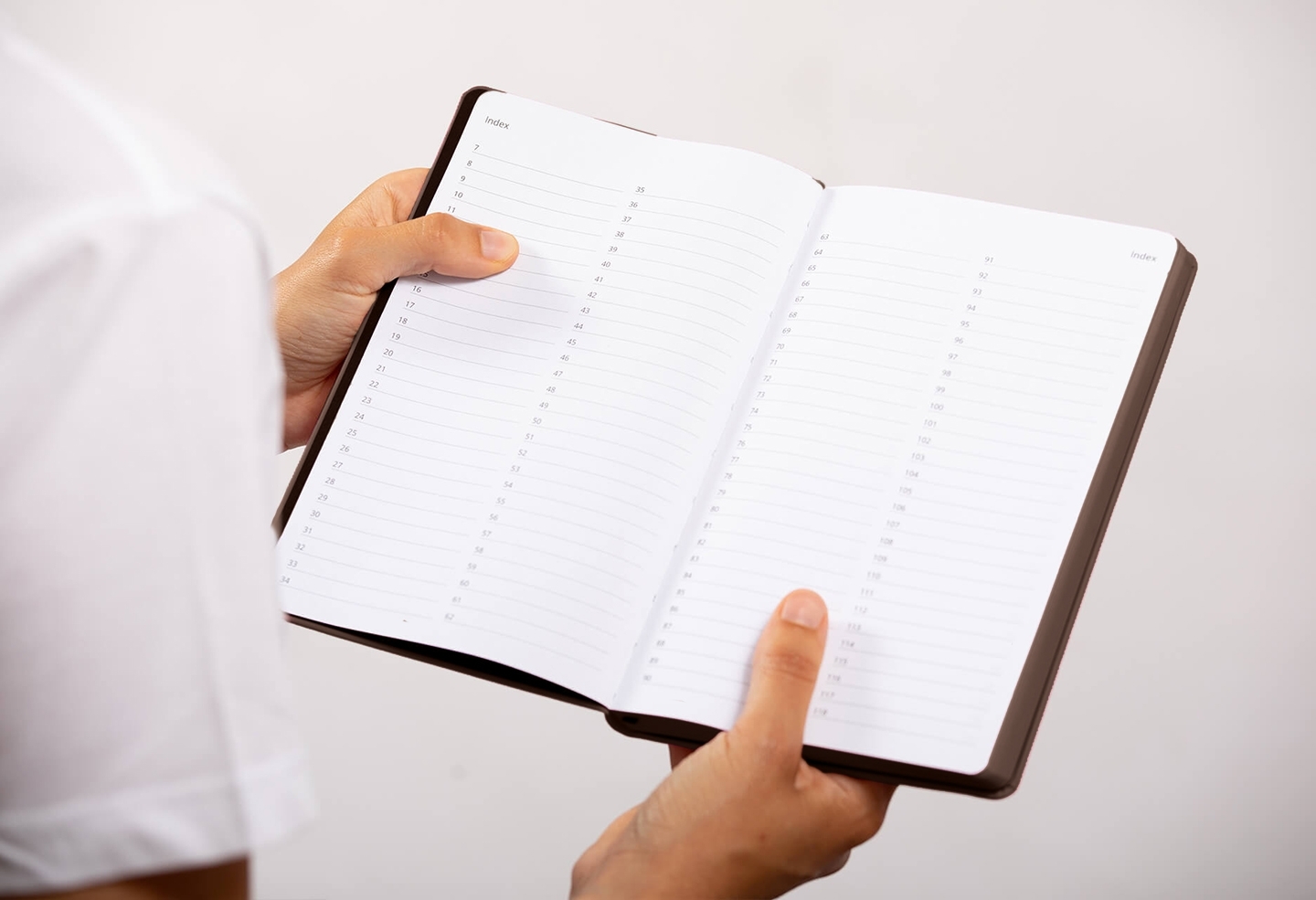 Carnet de note infirmière ouvert tenu en main par une professionnelle de santé – coloris chocolat
