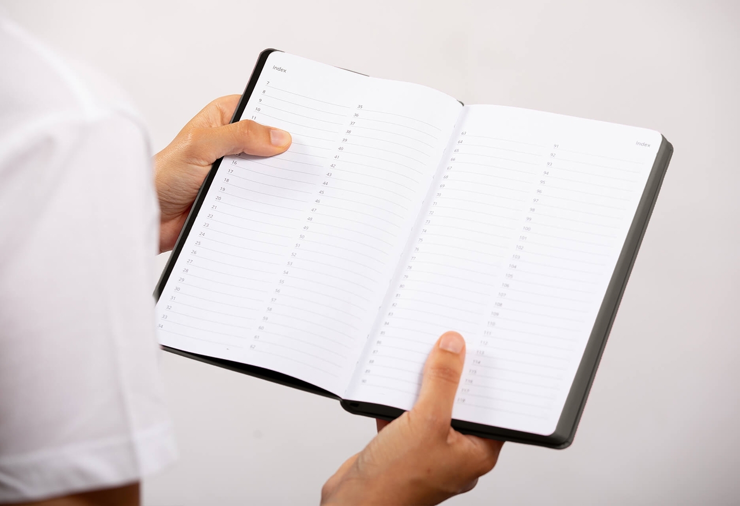 Carnet de note infirmière ouvert tenu en main par une professionnelle de santé – coloris gris