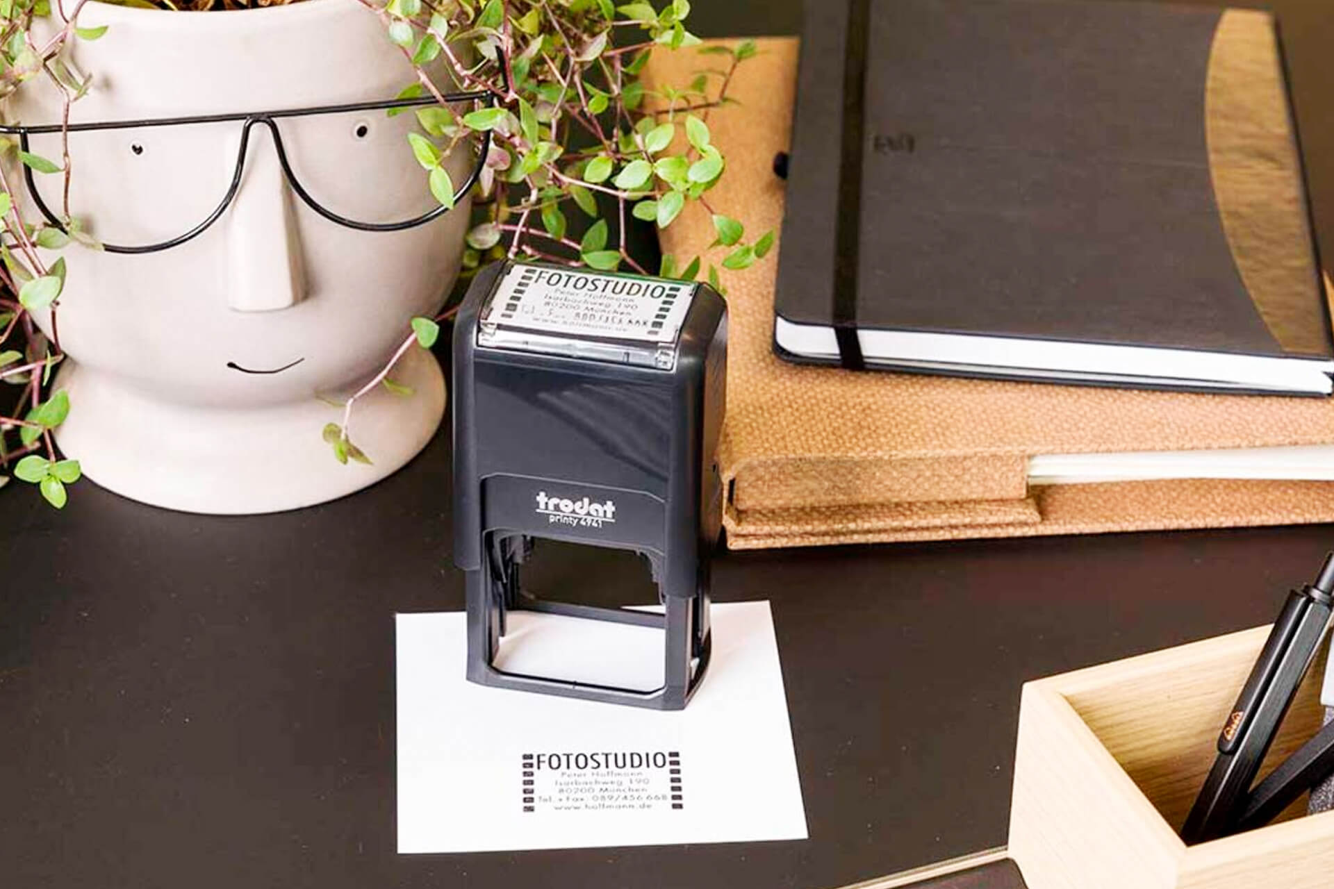 Tampon de bureau Original Printy coloris noir en situation &ndash; empreinte visible sur document, d&eacute;cor bureau moderne avec plante